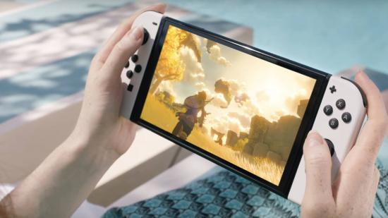 A person is sitting on a deckchair playing the new Nintendo Switch OLED Model and the sequel to Breath Of The Wild