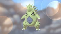 Pokémon Go's Tyranitar against a rocky background