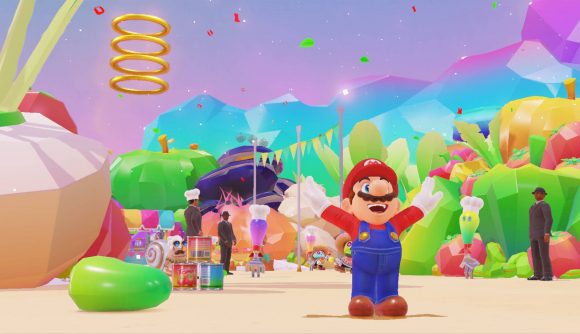 Mario stands tall with his arms in the air, appearing in a kingdom where everything is brightly coloured food