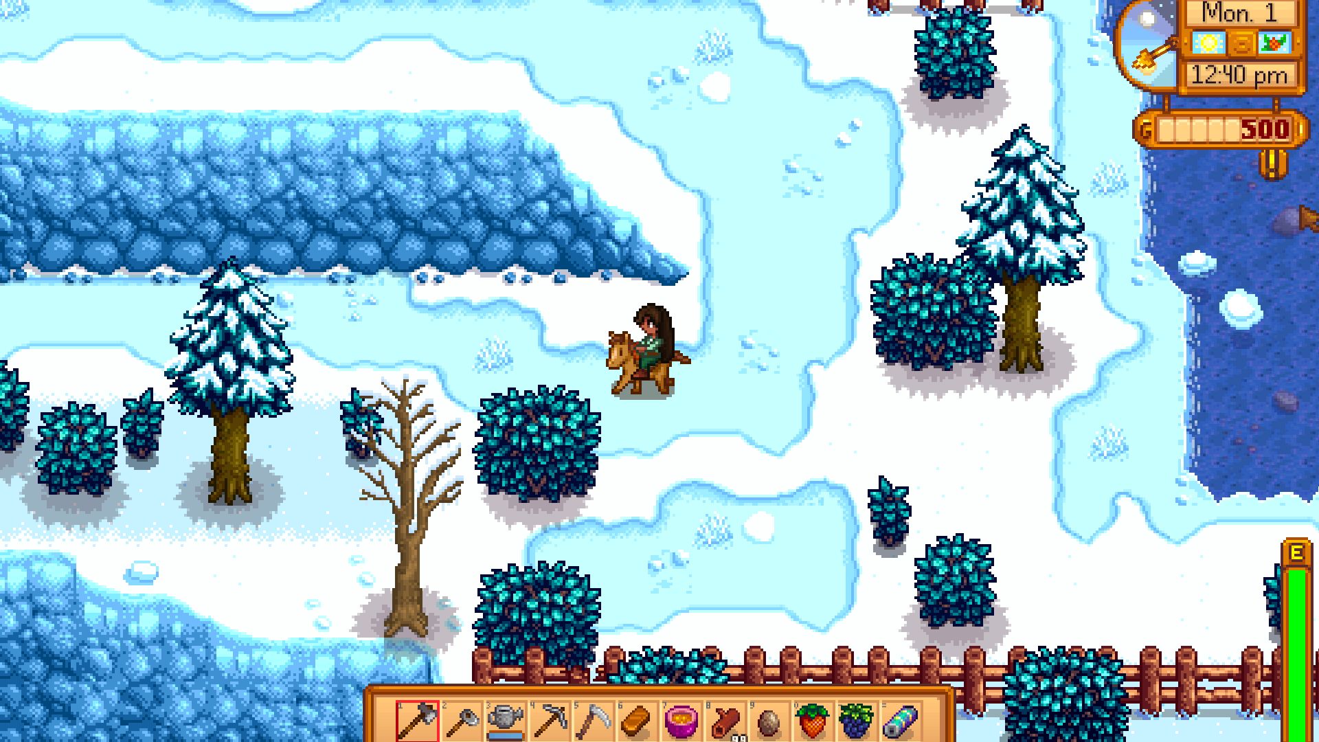 A character on a pony, on an icy field with trees and bushes, in the relaxing game Stardew Valley.