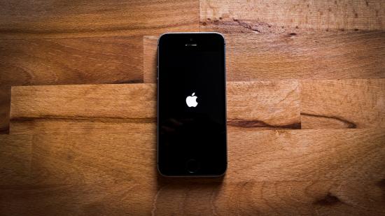 Best VPN for iPhone - an image shows an iPhone sitting on a wooden surface.