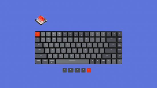 A picture of a mechanical keyboard in various shades of grey, with one big red key in the top left corner.