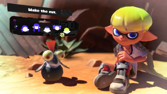 A short, shaved-sided Splatoon 3 hairstyle. Shown off by a character with grey shoes, yellow hair, sat in the desert with a cliff face behind them,and a small cute fish creature with an orange tuft of hair coming out the top of their head, and the menu options for choosing the hairstyle above.