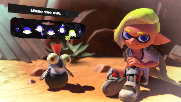 A long and thick Splatoon 3 hairstyle. Shown off by a character with grey shoes, yellow hair, sat in the desert with a cliff face behind them,and a small cute fish creature with an orange tuft of hair coming out the top of their head, and the menu options for choosing the hairstyle above.