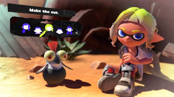A scruffy Splatoon 3 hairstyle. Shown off by a character with grey shoes, yellow hair, sat in the desert with a cliff face behind them,and a small cute fish creature with an orange tuft of hair coming out the top of their head, and the menu options for choosing the hairstyle above.