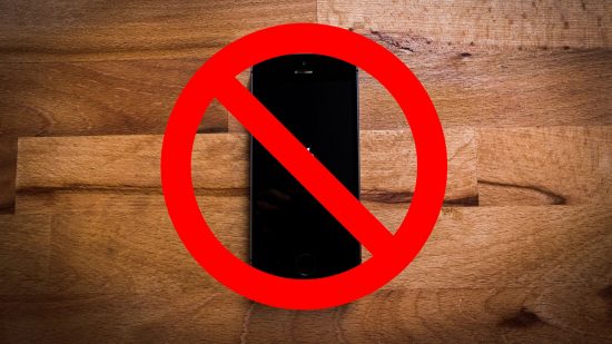 How to turn off live photos - an iPhone on a wooden floor behind a no entry sign