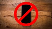 How to turn off live photos - an iPhone on a wooden floor behind a no entry sign