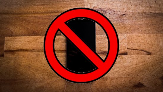 How to turn off Siri - A black iPhone on a wooden floor behind a no enter sign