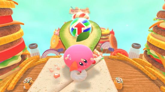 Kirby's Dream Buffet review: a gigantic Kirby rolls down a level based on burgers, about to jump on a large avocado and leap forward