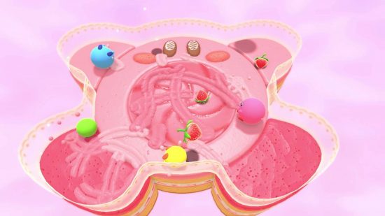 Kirby's Dream Buffet review: several different Kirbys roll around a level that looks like a giant Kirby cake