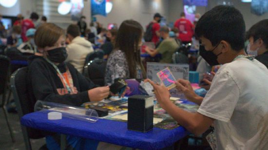 Pokemon Worlds 2022: two young players sit at a table, player the Pokemon Trading Card Game 