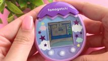 Promo art of a Tamagotchi Pix in the palm of someones hands as they load up the game
