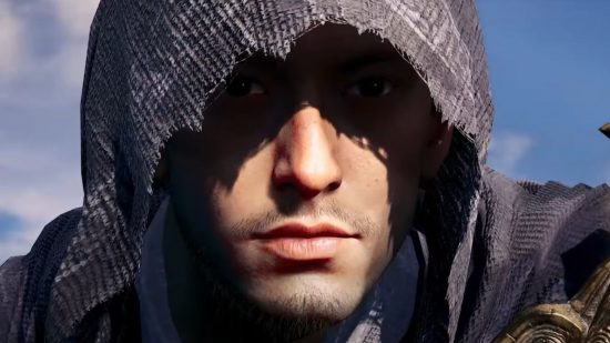 A man's face, their eyes and forehead shadowed by a hood over their head, white skin, stubble, mouth and nose lit in the sun, in front of a lightly-clouded blue sky, in a screenshot from a trailer for the Assassin's Creed mobile game.