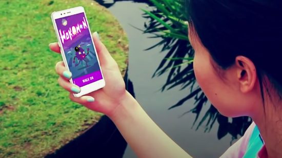 Fitbit apps - someone holding a phone with a purple screen that says "Wokamon" on it