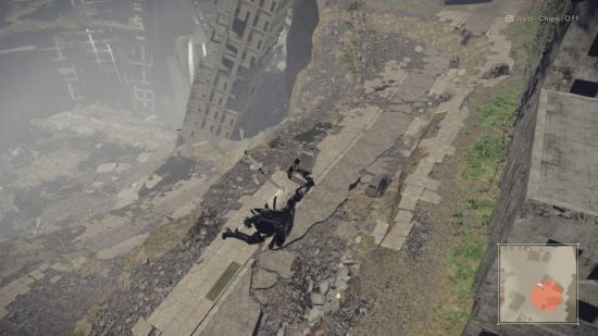 2B floating down via a drone-like machine in a dilapidated crater with a large skyscraper half-collapsed against the side of the crater.