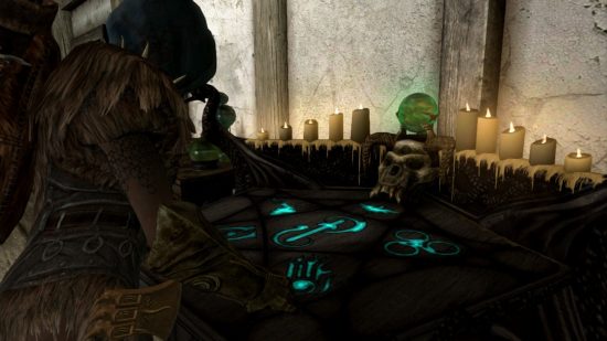 A woman in a hood and fur armour standing over a glowing countertop enchanting an item, for our Skyrim enchanting guide.