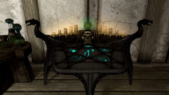 A glowing countertop with skulls, candles and strange glyphs on it. It's an arcane enchanter, for our Skyrim enchanting guide.