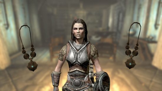 Skyrim's Lydia stood in a town surrounded by walls, with fire torches, leaves on the ground, and other medieval-esque elements. She is a woman in silver armour, with a silver helmet on her head and axe on her back.