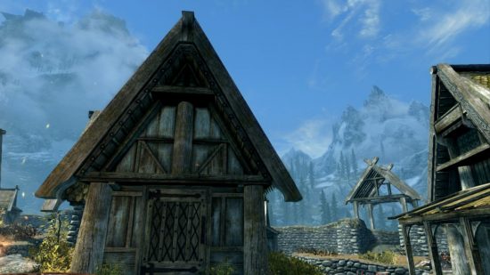Skyrim marriage: a house with a triangular roof made of wood against a bright, massive blues sky in a screenshot from Skyrim.
