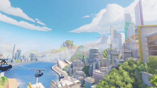 En Overwatch 2 -kartscene som viser et landskap med en bukt, store skyskrapere og mye grøntområder