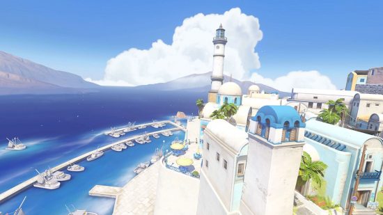 An Overwatch 2 map showing a scene of a Greek island with dense white buildings and a long blue sea in the distance.