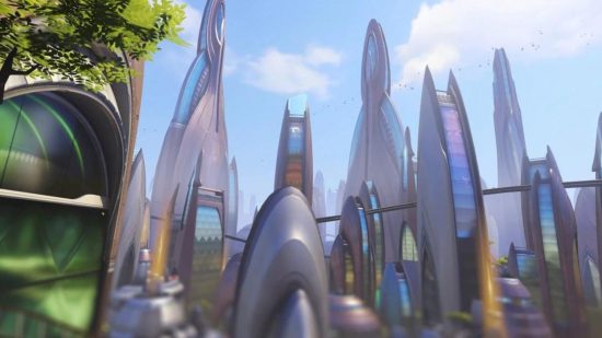 An Overwatch 2 map showing a scene showing curved futuristic buildings rising high into the sky.