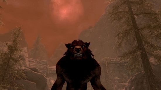 A Skyrim werewolf stands below a red moon is big in a red sky above tall pine trees.
