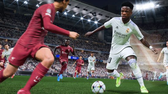 FIFA 23 online: a footballer in a white Real Madrid kit dribbling past another in a red kitwith other footballers wearing either colour kit and fan stands and floodlights in the very back.