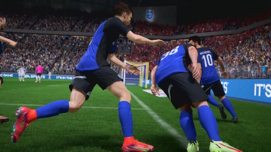 FIFA 23 pro clubs: three footballers in blue kits celebrating with the goal in the background,one tackling the other like it's rugby, the other close, ready to join in.