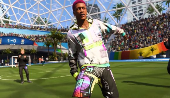 FIFA 23 Volta: a player in a colourful tracksuit with red hair stands on a green five-a-side pitch with another player in the back to the right. He looks like he is celebrating.