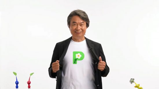 Shigeru Miyamoto birthday: Shigeru Miyamoto, a seventy year old japanese man in a white t-shirt with a P on it and black blazer. He has silverish hair. He is holding the lapels of blazer out to show off the P logo on his white t shirt. He has a big grin.
