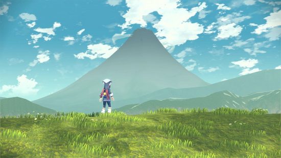 2022 Pocket Tactics year-in-review: a character in blue stands looking away from the camera on a grassy hill overlooking a giant mountain in the mist in a shot from Pokemon Legends: Arceus.