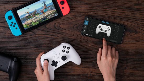 8BitDo Ultimate Controller review: a top down view shows a pair of hands using the 8BitDo Ultimate controller for Switch, while also adjusting the settings using the Ultimate Software for iPhone