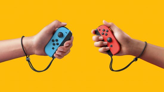 Nintendo Switch Joy-Con drift - a pair of Joy-Con controllers, one blue and one red, held in hands on a mango-yellow background. They are about the size of a Mars Bar, with rounded edges on their outsides, flat edges on the inside with a little mechanism to attach to the console. They have opposite analogue sticks and four face buttons on each.