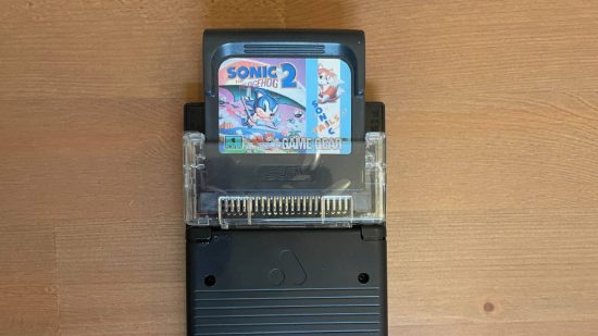 Analogue Pocket review: A analogue Pocket is visible with a Game Gear adapter and a copy of Sonic The Hedgehog for game Gear