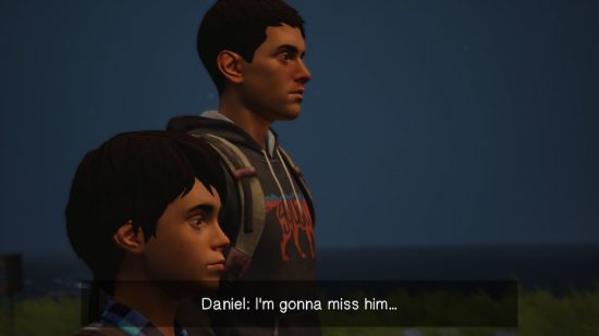 Life is Strange 2 review: Sean and Daniel Diaz, two Hispanic young boys, stood next to each other facing towards the right of the image. Subtitles read 'Daniel: I'm gonna miss him' on a black background at the bottom of the screen. The sky is dark and the scene is in low light.