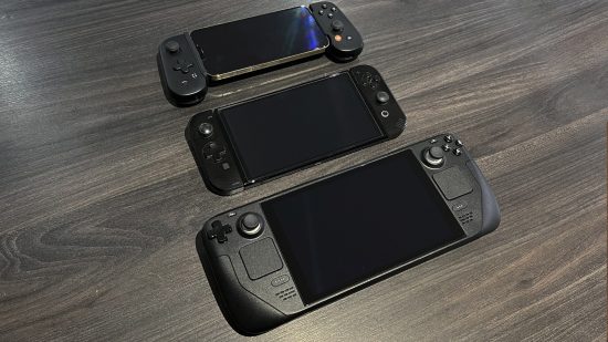 Steam Deck review - a mobile phone, a Switch OLED, and a Steam Deck lying next to each other on a table