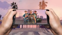 GTA V mobile - two hands holding a phone with the three GTA V boys on the screen