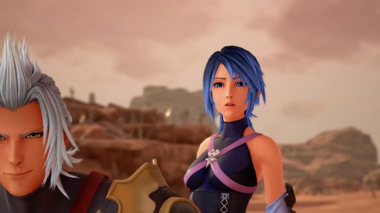 Kingdom Hearts Aqua, a woman with blue hair in a sort of bob, a black sleeveless armour that looks like leather, with straps in a cross across the chest, spiky boots and a key as a blade. Here, you can see her next to a grey haired man, looking very concerned, just a shot of her from the waist up.