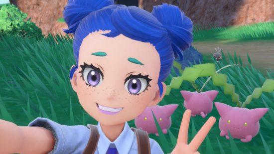 Pokemon accessibility: A Pokemon Violet player character with dark blue space buns, teal short eyebrows, purple eyes and freckles, smiling at the camera and doing a peace sign. Behind them are three pink Hoppip and a tiny Scatterbug peeping up from behind the grass in the background.