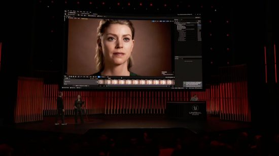 Metahuman editor demo on a stage at GDC 2023. two people stand on the stage below a massive screen with a. virtual woman face on it.