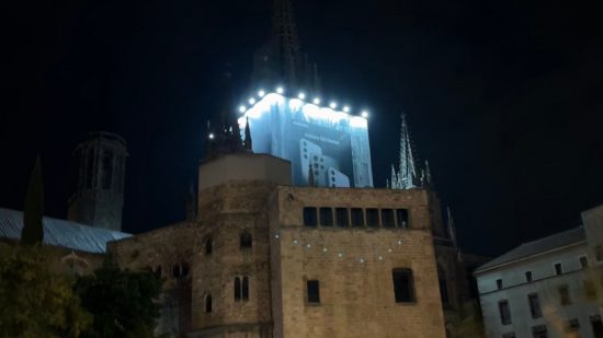Samsung Won-Joon Choi interview - the Barcelona Cathedral at night, a large old building, with building work near its spire covered by a Samsung advert.