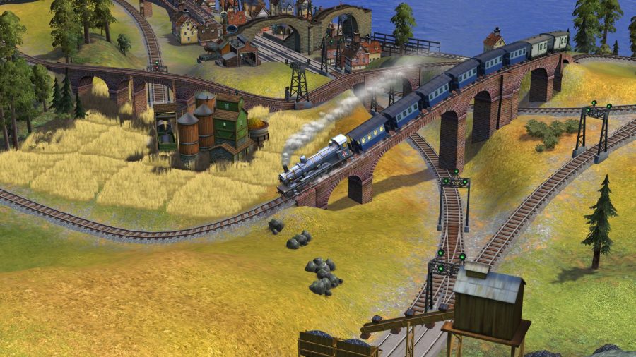 Sid Meier's Railroads icon showing a playlet style train going over a red brick bridge along grass with tiny houses, trees and industrial buildings dotted around.