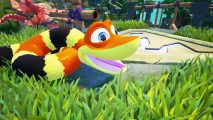 Snake games: A screenshot from Snake Pass showing a close-up of Noodle the snake in the tall grass smiling.