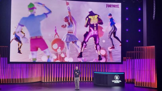 Tim Sweeney stands below a massive screen on a stage at State of Unreal 2023. On the screen is multiple Fortnite characters looking away.