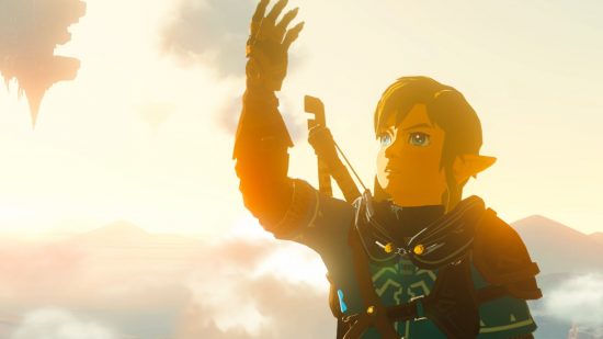 Nagłówek daty premiery The Legend of Zelda Tears of the Kingdom pokazuje link, małego blondyna w zbroi trzymającego rękę w powietrzu na tle jasnego, pochmurnego nieba z pływającą wyspą w prawym górnym rogu.