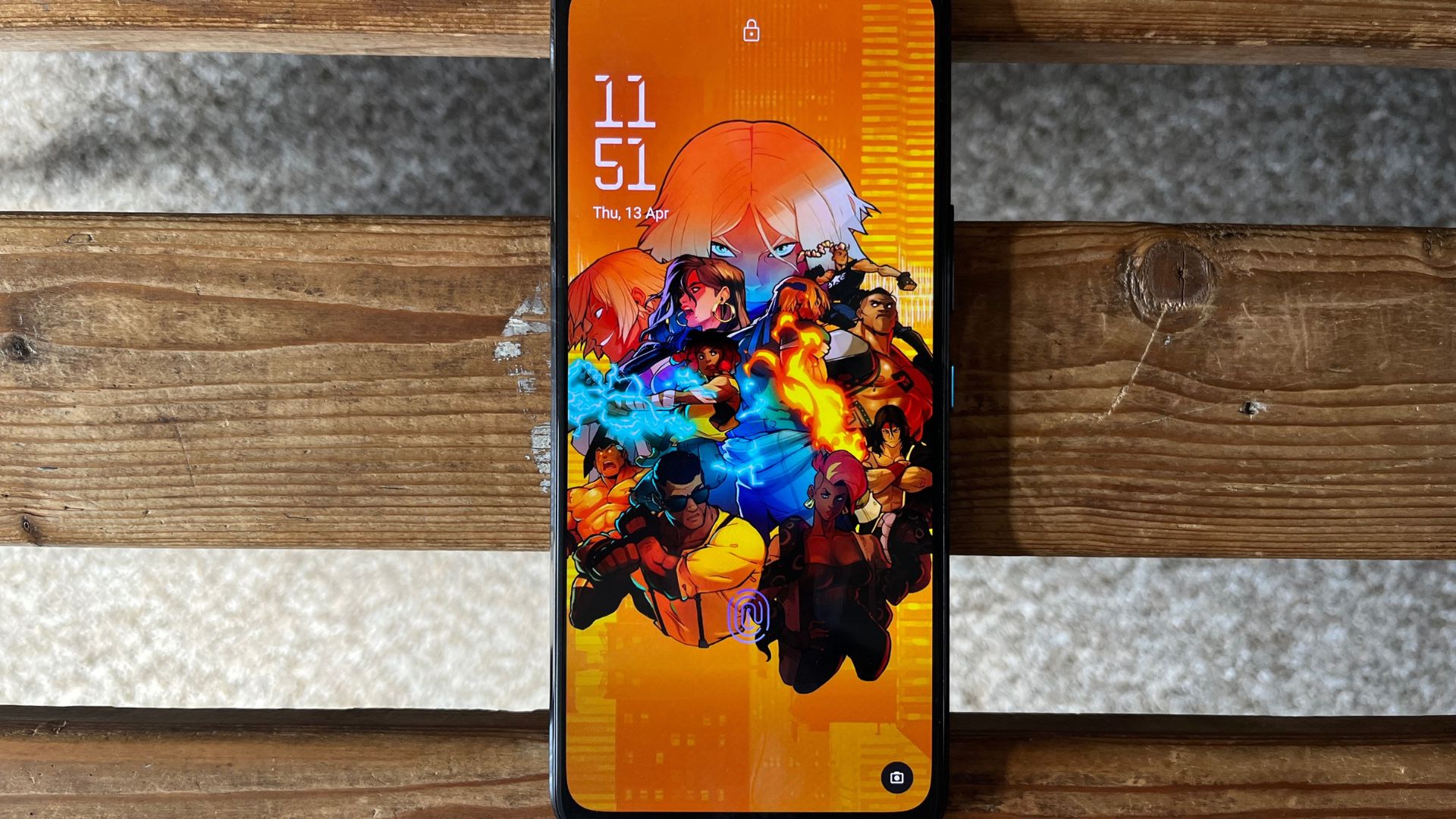 Asus ROG Phone 7 review - the phone on its back showing an orange screen with cartoon characters on it in a collage.