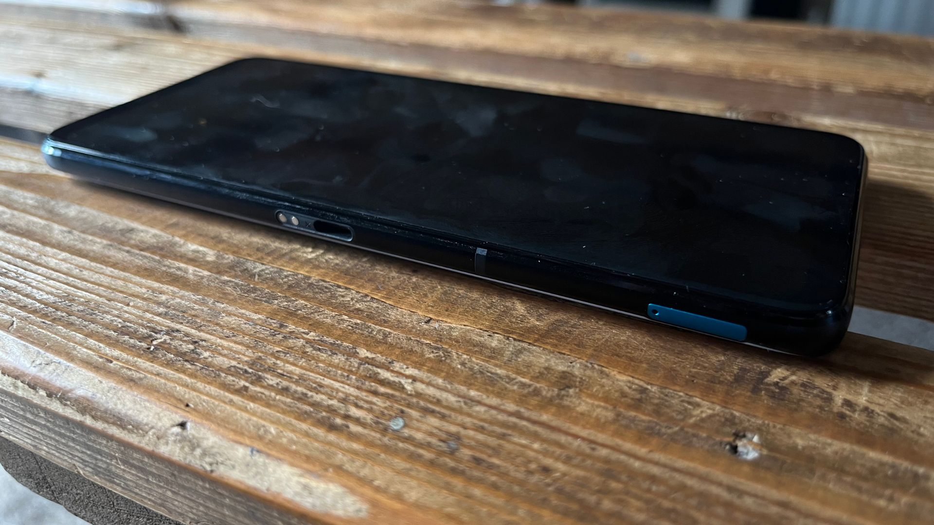 Asus ROG Phone 7 review - the phone on its back all black screen off lying on a wooden surface.