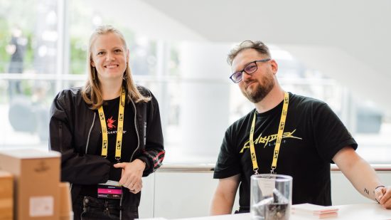 Digital Dragons Conference 2023 programme: A photograph of two CD Projekt Red representatives in black tshirts with yellow lanyards at 2022's DD Conference.