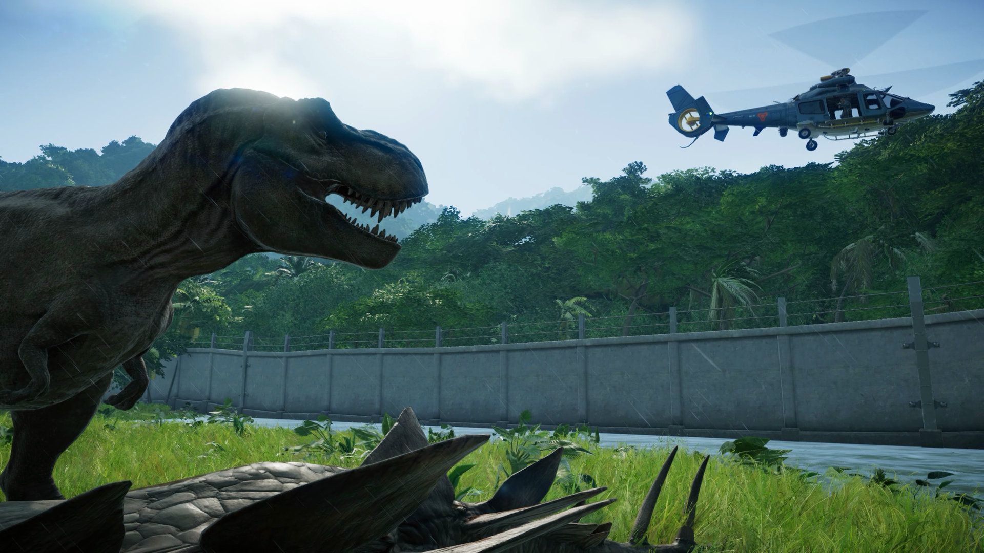 Jurassic World games - a t-rex looks at a helicopter above a fence at the end of a grassy patch, in from of a dense jungle.